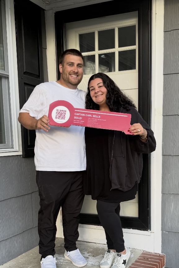 Carly and Anthony celebrating their new home with a Captain Carl Sells sold key